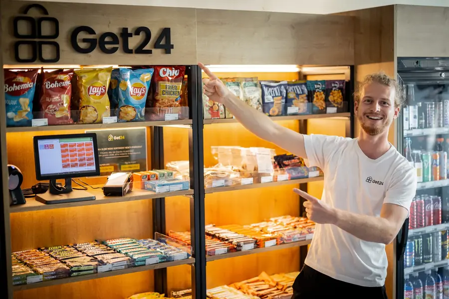 Adam Dostál ukazuje nabídku v regálech micro-marketu GET24